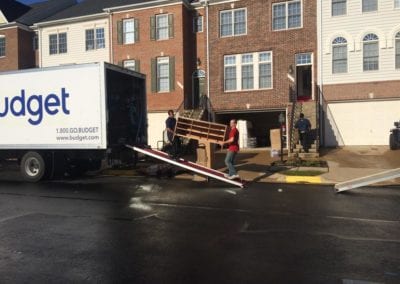 Two men loading furniture into box truck