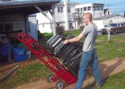 Man moving large object with hand truck
